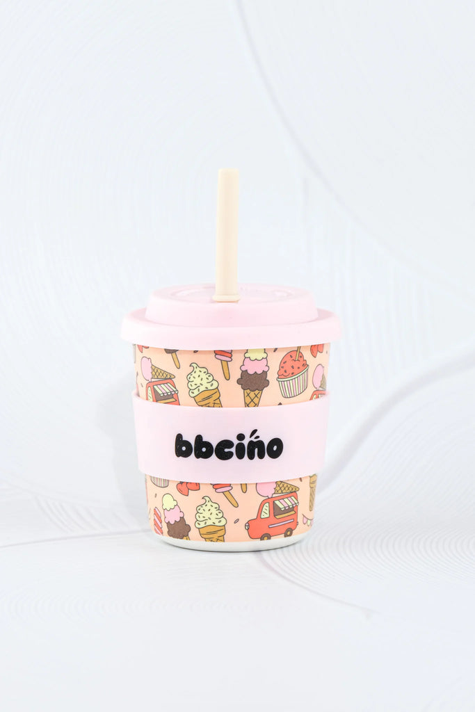 Pink cup with ice cream cone design and straw on a white background